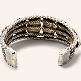 Silver bracelet with textured design on a white background