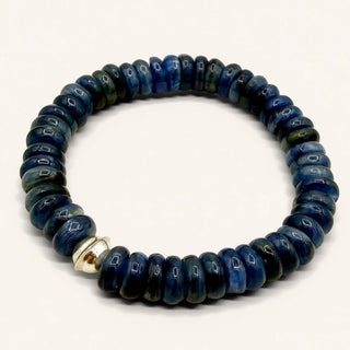 Blue beaded bracelet with a gold accent on a white background