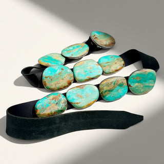 Black belt with turquoise stone accents on a neutral background