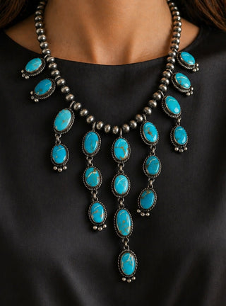 Turquoise necklace with silver beads on a black background