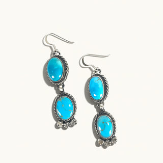 Pair of earrings with turquoise stones on a white background