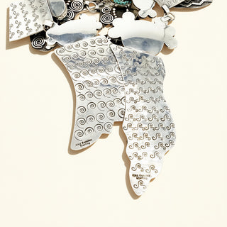 Silver jewelry stamp with intricate patterns on a plain background