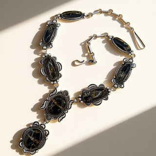 Silver necklace with black stones on a beige background