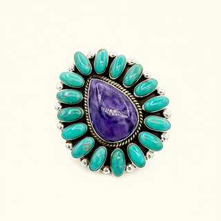 Ring with purple teardrop stone and turquoise stones on a white background