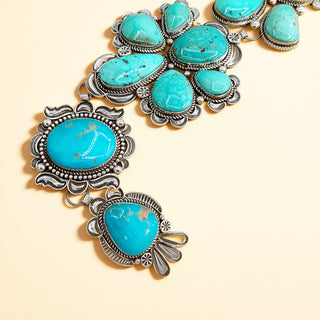 Turquoise stone necklace with silver accents on a beige background