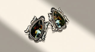 Pair of silver earrings with teardrop-shaped gemstones on a light background