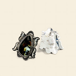 Silver earrings with black stone on a beige background