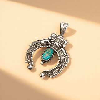 Silver pendant with turquoise stone on a beige background