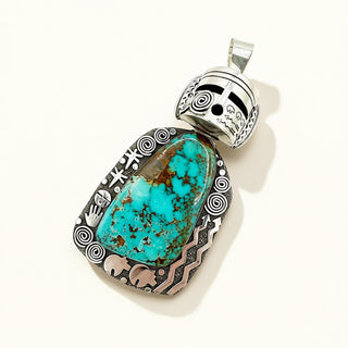 Turquoise pendant with silver decorative elements on a white background