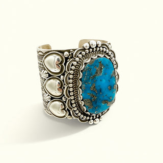 Silver cuff with turquoise stone on a beige background