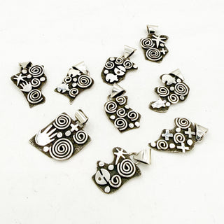 Set of silver jewelry charms with intricate patterns on a white background