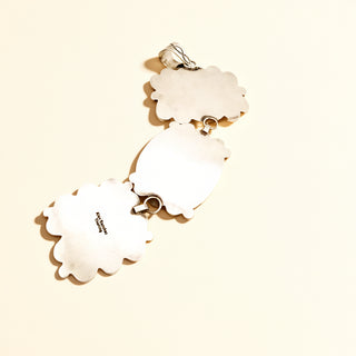 Silver pendant stamp on a beige background