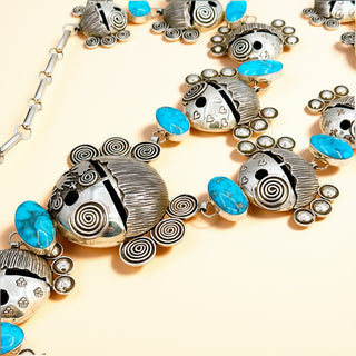 Silver necklace with turquoise stones on a beige background