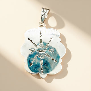 Silver pendant on a beige background