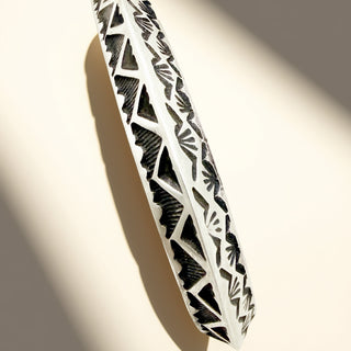 Decorative cuff with intricate black patterns on a beige background