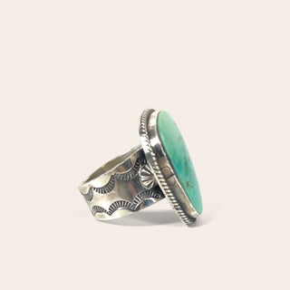 Silver ring with turquoise stone on a light gray background