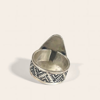 Silver ring with geometric pattern on a light gray background