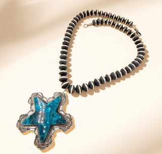 Necklace with Navajo pearls and turquoise  star pendant on a beige background