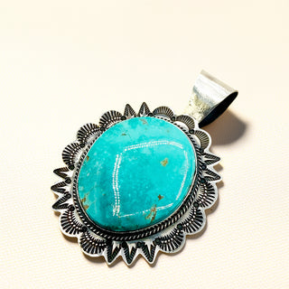 Turquoise pendant against a beige background