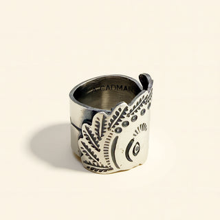 Silver ring with design on a beige background