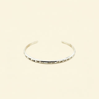 Silver bangle on a beige background