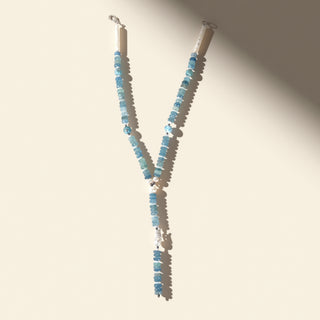 Necklace with blue beads on a beige background
