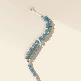 Necklace with blue beads on a beige background