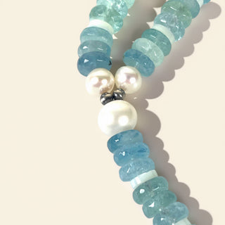 Necklace with blue and white beads on a beige background