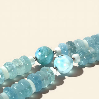 Necklace with light blue beads on a beige background