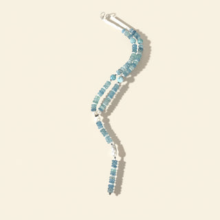 Blue beaded necklace on a beige background