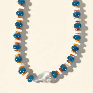 Necklace with blue, orange, and white beads on a beige background