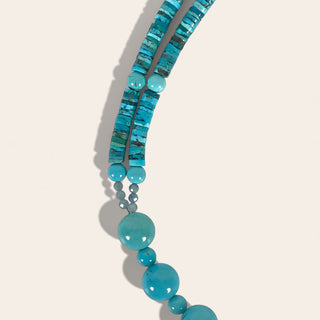 Turquoise beaded necklace on a light beige background