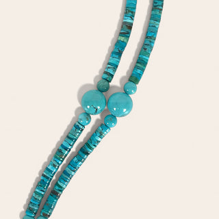 Turquoise beaded necklace on a light beige background