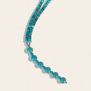 Turquoise beaded necklace on a light beige background