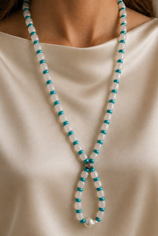 Necklace with blue and white beads on a beige background