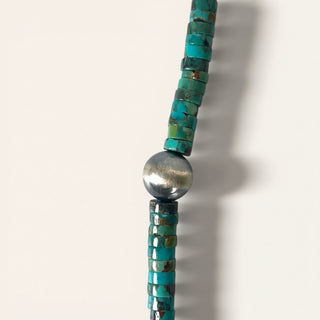 Turquoise beaded necklace with a silver clasp on a white background