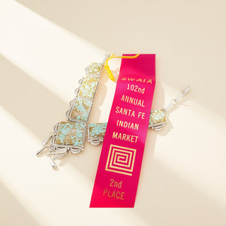 Jewelry with a pink ribbon award on a beige background