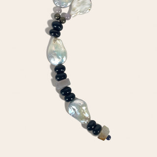 Necklace with pearls and dark beads on a light background