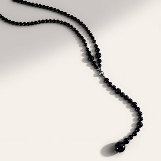Black beaded necklace on a white background