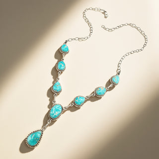 Turquoise necklace with silver chain on a beige background