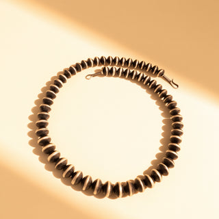 Necklace with black Navajo pearls on a beige background