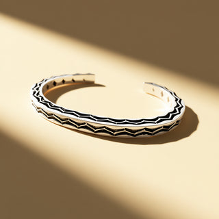 Silver and black cuff on a beige background