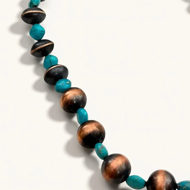 Necklace with brown and turquoise beads on a white background