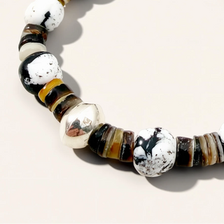 Beaded bracelet with black, white, and brown beads on a light background