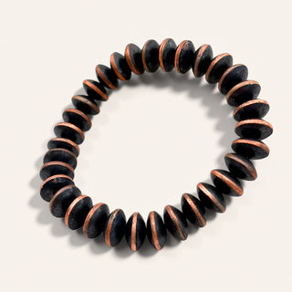 Black and copper beaded bracelet on a light gray background
