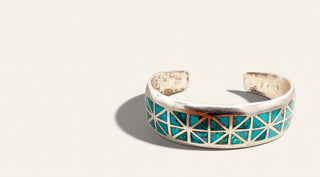 silver cuff with turquoise stones on a beige background
