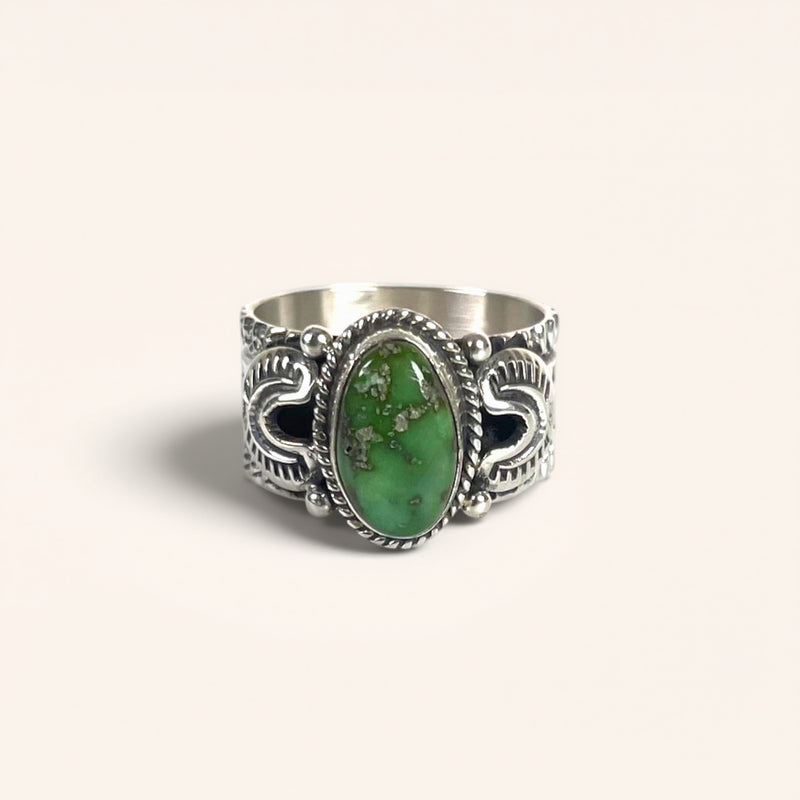 Silver ring with a green stone on a white background