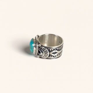 Silver ring with turquoise stone on a beige background