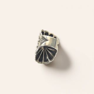 Silver ring with intricate design on a white background