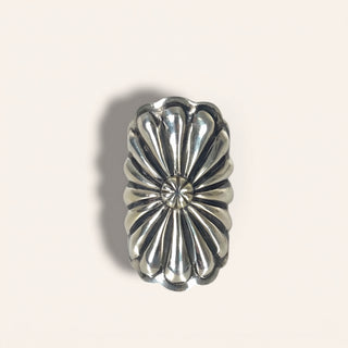 Silver concho on a light gray background